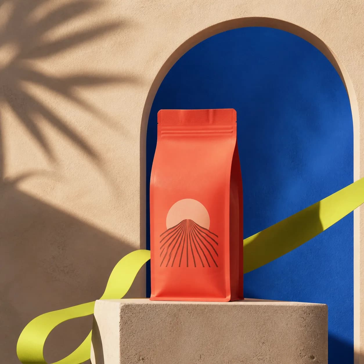 Coral coffee package in a cobalt studio scene